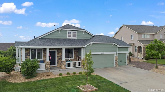 craftsman inspired home featuring a garage, a front lawn, and covered porch