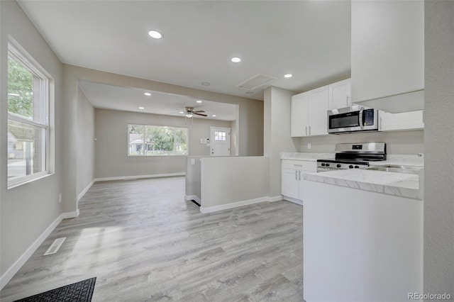 1216 Norwood Ave, Colorado Springs, CO 80905 - kitchen featuring stainless steel appliances, white cabinets, recessed lighting, light wood-style flooring, and light stone counters