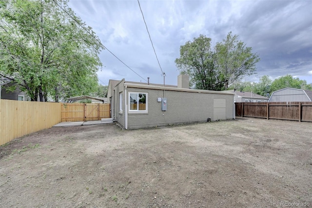1216 Norwood Ave, Colorado Springs, CO 80905 - rear view of house featuring a chimney, a fenced backyard, and brick siding