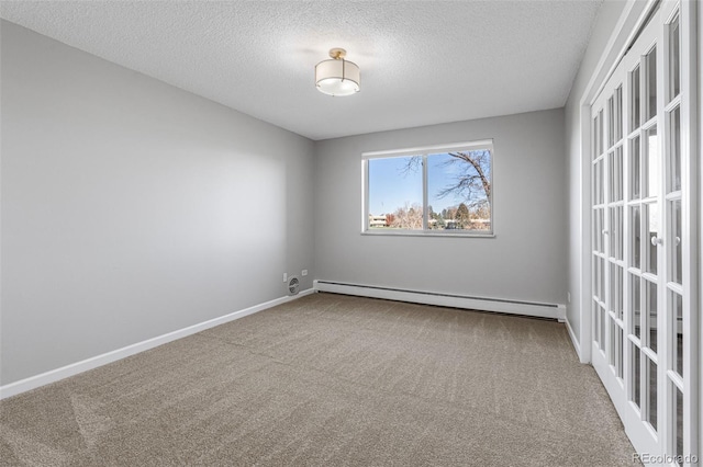 carpeted spare room with a baseboard radiator, french doors, and a textured ceiling