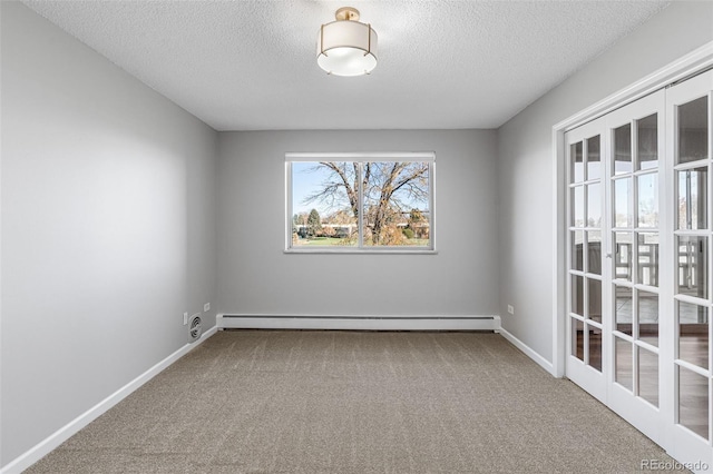 carpeted empty room with a textured ceiling and a baseboard heating unit