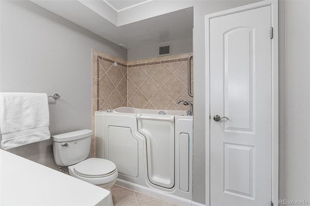 bathroom with a bath, tile patterned floors, and toilet