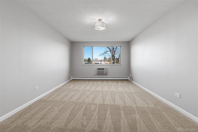 empty room featuring light carpet, a textured ceiling, a wall mounted AC, and baseboard heating