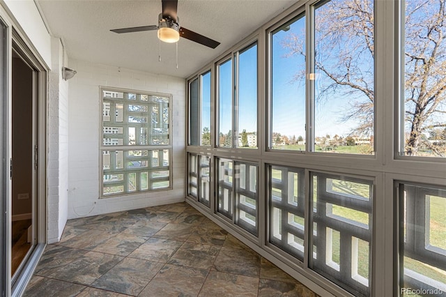 unfurnished sunroom with ceiling fan