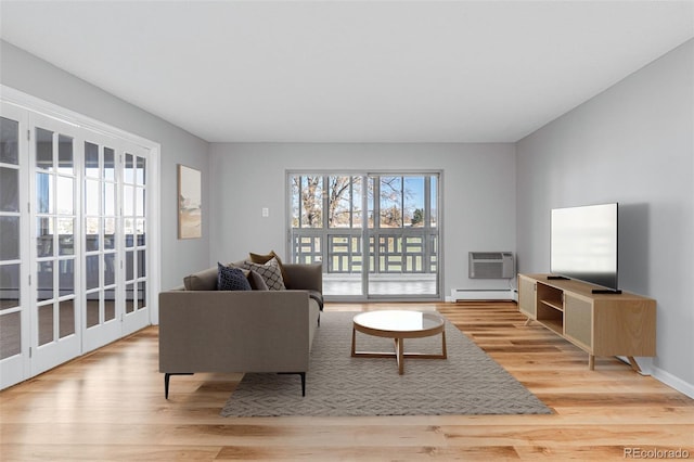 living room featuring a baseboard radiator, a wall mounted AC, and light wood-type flooring