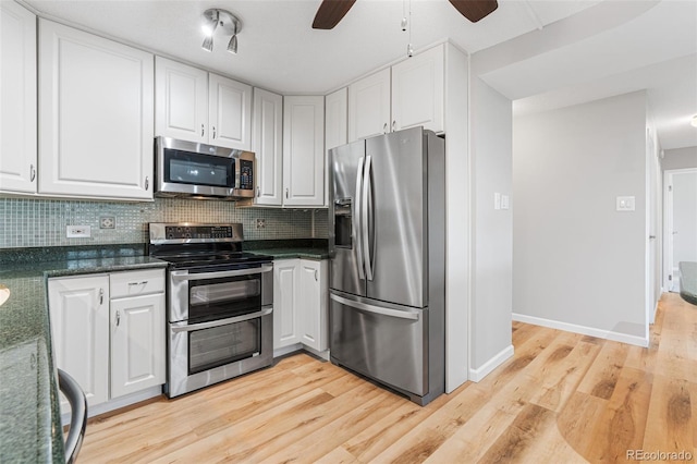 kitchen with appliances with stainless steel finishes, white cabinets, and decorative backsplash