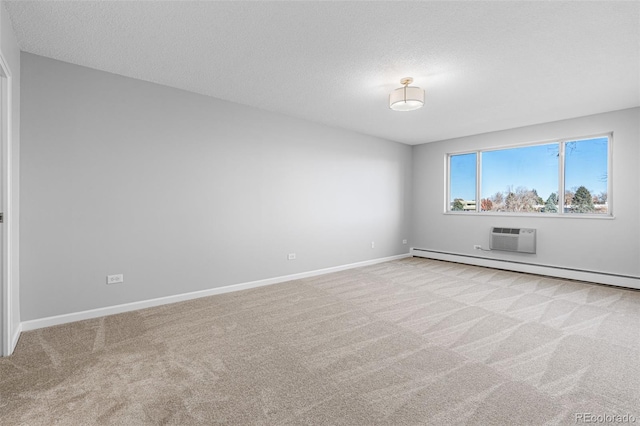 spare room featuring a baseboard radiator, a wall mounted air conditioner, light carpet, and a textured ceiling