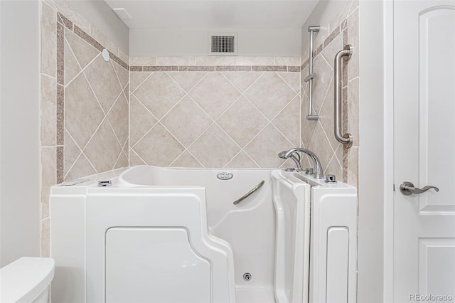 bathroom with a bath and tile walls