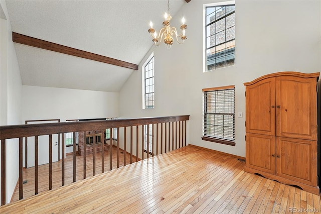 10102 W Ida Ave Unit 214, Littleton, CO 80127 - bonus room with a chandelier, light wood-style floors, high vaulted ceiling, beam ceiling, and baseboards