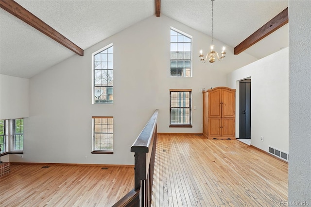 10102 W Ida Ave Unit 214, Littleton, CO 80127 - staircase featuring high vaulted ceiling, beam ceiling, hardwood / wood-style floors, a chandelier, and baseboards