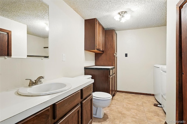 10102 W Ida Ave Unit 214, Littleton, CO 80127 - bathroom featuring washer and dryer, toilet, a textured ceiling, vanity, and tile patterned floors
