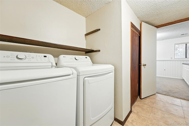 10102 W Ida Ave Unit 214, Littleton, CO 80127 - clothes washing area featuring washing machine and dryer, a textured ceiling, light colored carpet, and light tile patterned floors