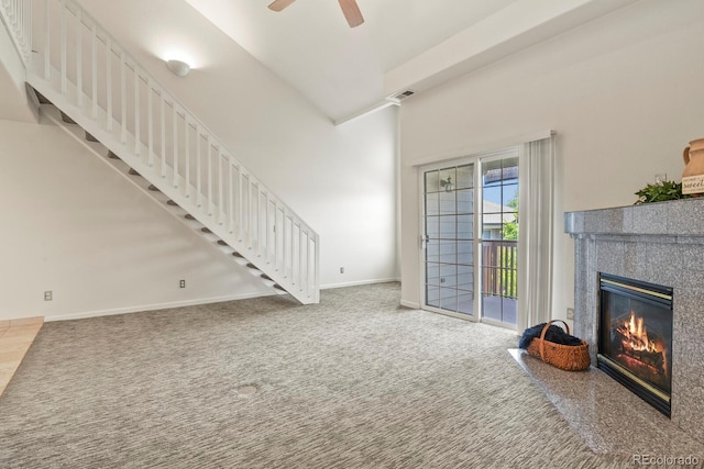 11085 Huron St Unit 1108, Northglenn, CO 80234 - carpeted living room with a glass covered fireplace, stairway, a ceiling fan, and a high ceiling