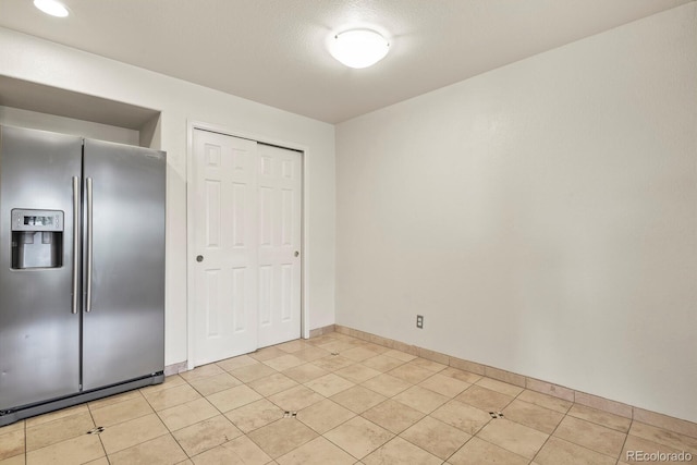 11085 Huron St Unit 1108, Northglenn, CO 80234 - unfurnished bedroom with stainless steel fridge, a closet, and light tile patterned floors