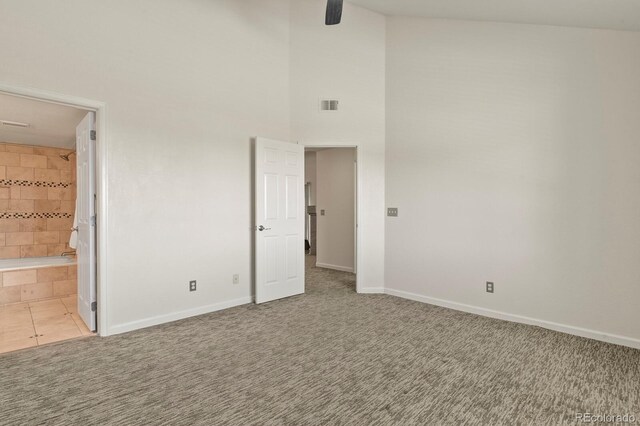 11085 Huron St Unit 1108, Northglenn, CO 80234 - unfurnished bedroom featuring a towering ceiling, carpet floors, ensuite bath, a ceiling fan, and tile patterned floors