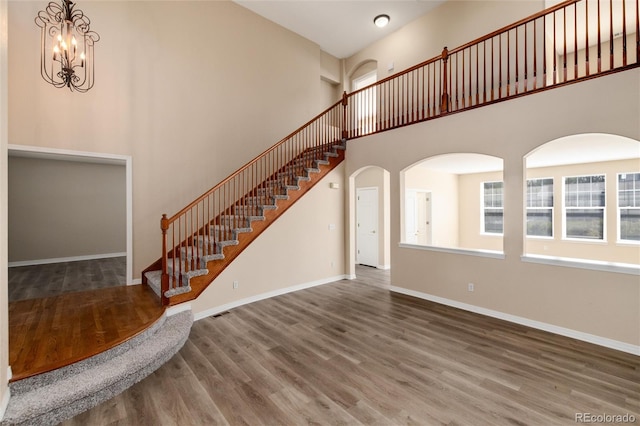 interior space featuring a high ceiling, an inviting chandelier, and hardwood / wood-style floors