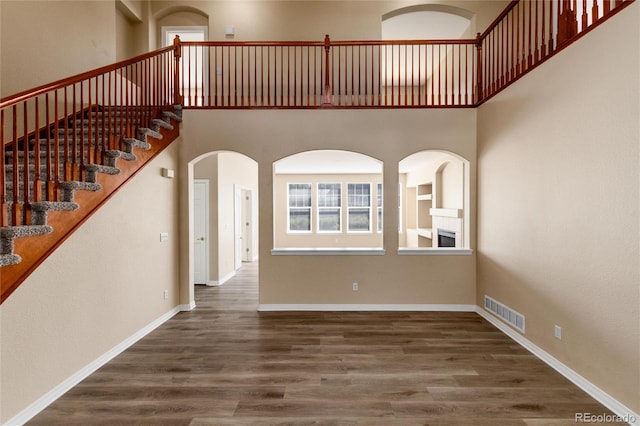 interior space featuring dark hardwood / wood-style flooring and a high ceiling