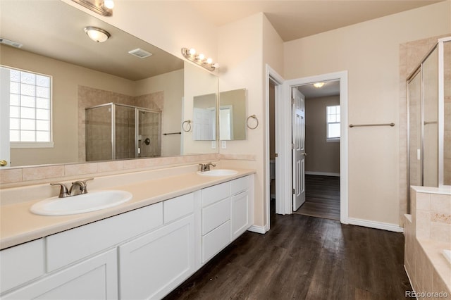 bathroom with a wealth of natural light, vanity, shower with separate bathtub, and hardwood / wood-style flooring