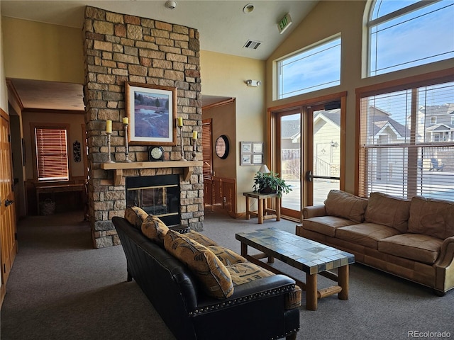 carpeted living room with a fireplace and high vaulted ceiling