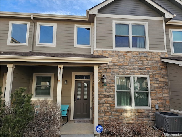 view of front facade with stone siding and central air condition unit