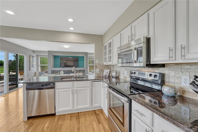 901 Sage Sparrow Cir, Highlands Ranch, CO 80129 - kitchen featuring appliances with stainless steel finishes, a sink, a peninsula, white cabinetry, and recessed lighting