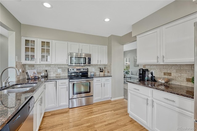901 Sage Sparrow Cir, Highlands Ranch, CO 80129 - kitchen featuring appliances with stainless steel finishes, a sink, white cabinetry, dark stone counters, and recessed lighting