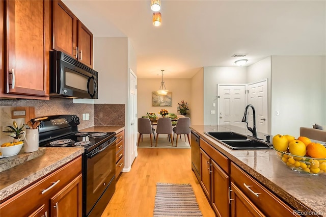 2705 S Danube Way Unit 306, Aurora, CO 80013 - kitchen featuring black appliances, a sink, light wood-style floors, backsplash, and brown cabinetry
