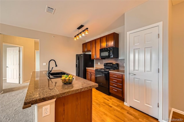 2705 S Danube Way Unit 306, Aurora, CO 80013 - kitchen featuring black appliances, a sink, tasteful backsplash, brown cabinets, and light wood-style floors