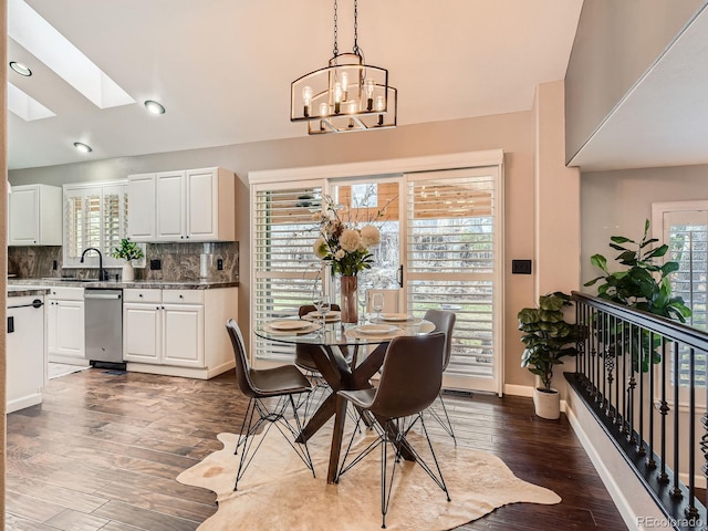 dining room with baseboards, dark wood-style flooring, a wealth of natural light, and an inviting chandelier