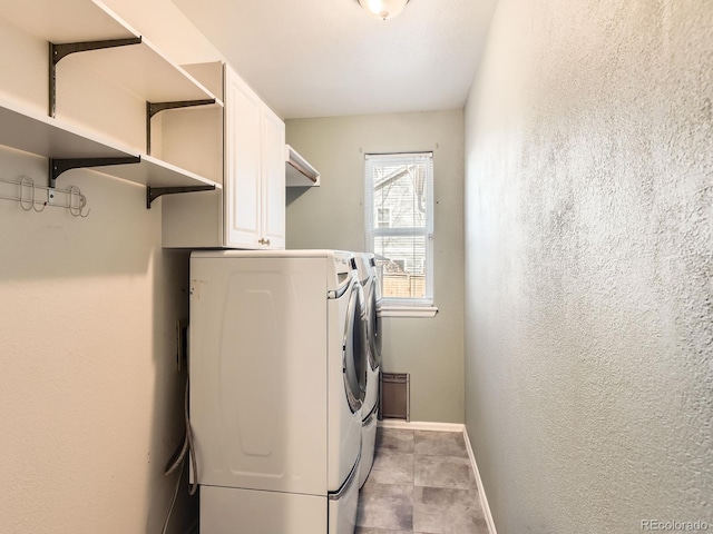 laundry room with a textured wall, cabinet space, independent washer and dryer, and baseboards