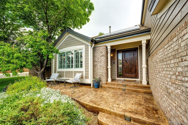 view of exterior entry featuring brick siding