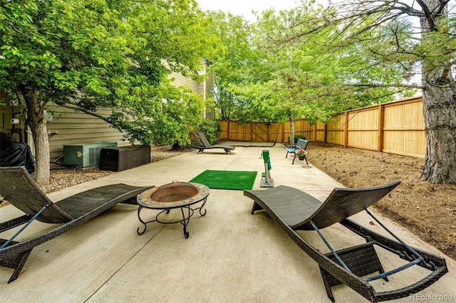 view of patio with an outdoor fire pit, a fenced backyard, and cooling unit