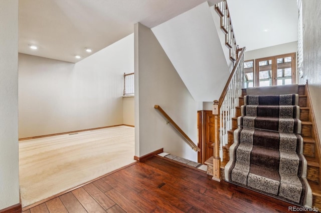 stairway featuring wood-type flooring, baseboards, and recessed lighting