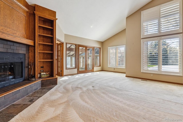 unfurnished living room with a fireplace, baseboards, high vaulted ceiling, and carpet