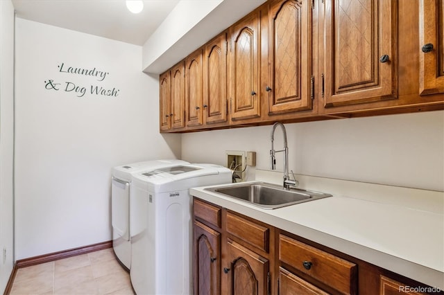 washroom with cabinet space, washer and dryer, and baseboards