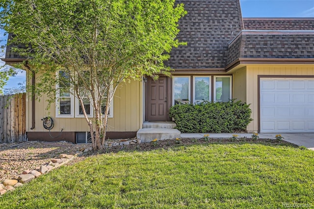 entrance to property with a shingled roof and an attached garage