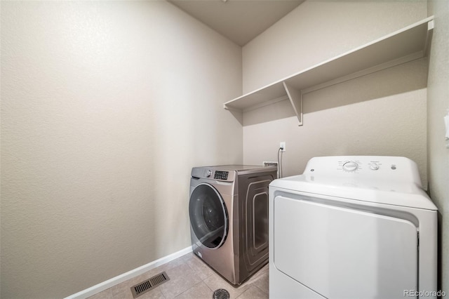 17028 Osage St, Broomfield, CO 80023 - laundry room featuring washing machine and dryer and light tile patterned flooring