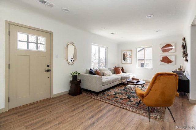 living area featuring recessed lighting, visible vents, baseboards, and wood finished floors