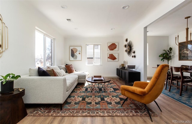 living room with a wealth of natural light, visible vents, wood finished floors, and recessed lighting