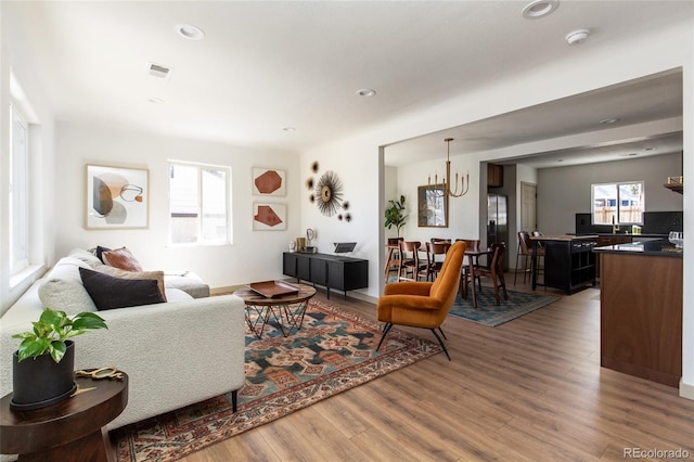 living area featuring recessed lighting, wood finished floors, and visible vents