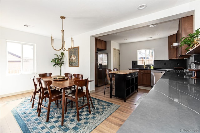 dining room featuring light wood-style flooring, recessed lighting, visible vents, and baseboards