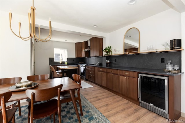 dining area with light wood-style flooring, recessed lighting, and beverage cooler