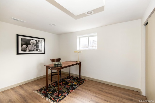 office area featuring visible vents, baseboards, and wood finished floors