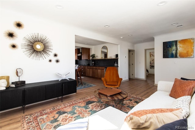 living area with recessed lighting, baseboards, and wood finished floors