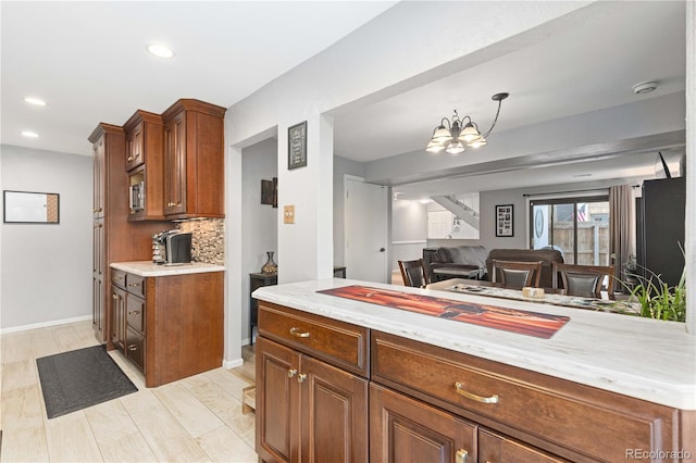 kitchen with tasteful backsplash, baseboards, brown cabinets, and recessed lighting