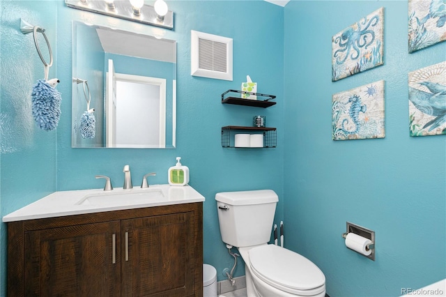 bathroom featuring toilet, visible vents, and vanity