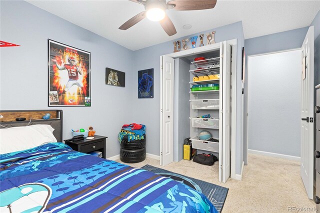 bedroom with a closet, light carpet, ceiling fan, and baseboards