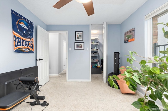 workout area with light carpet, baseboards, and a ceiling fan