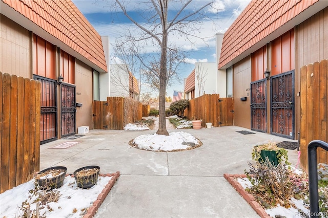 snow covered patio with a gate and fence