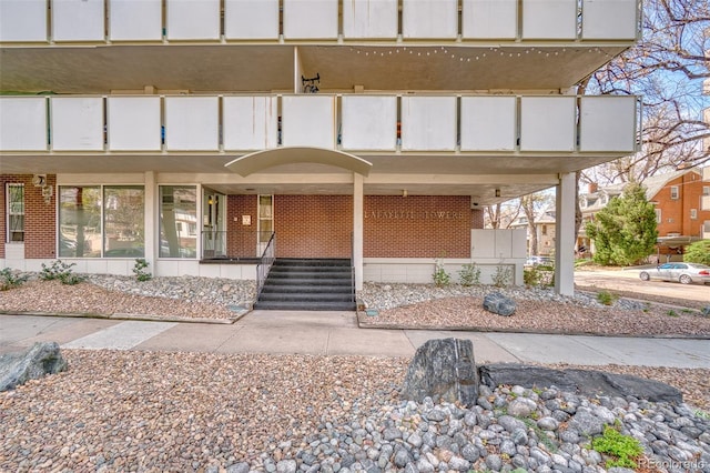 view of exterior entry featuring brick siding